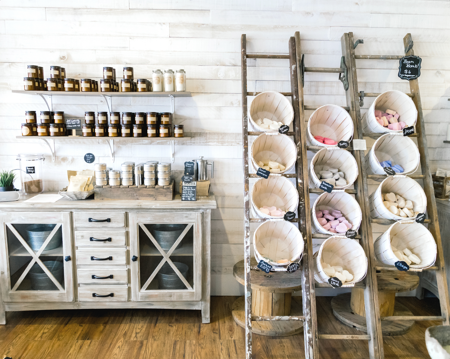 A wall of a Modern Roots retail location in Minnesota featuring buckets of bath bombs and a wall of hydrating skin treatments